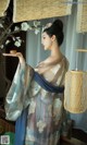 A woman in a blue and white kimono holding a wooden object.