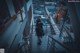 A person standing on a stairway in an industrial area.