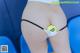 A woman in a thong with a tennis ball in her butt.